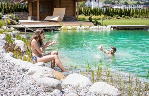 Illuminated indoor pool with stylish wood design and cozy loungers for relaxing evenings